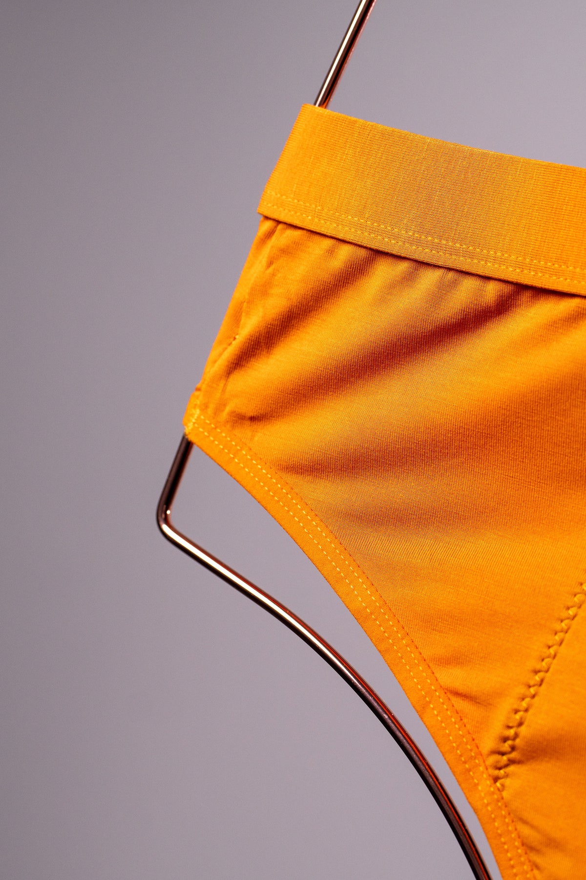 Mustard leak-proof brief on a copper hanger